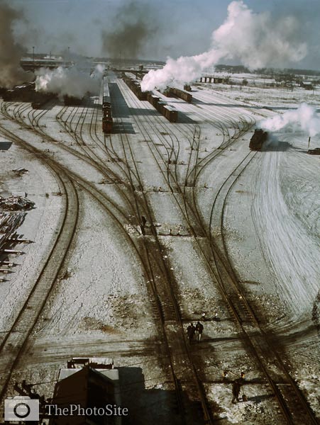 Steam rising from trains in snow covered tracks - Click Image to Close